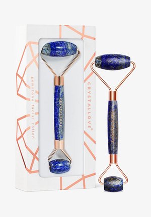 Rullo per il viso in pietra blu con estremità in lapislazzuli lucido, accenti in metallo dorato e un design di imballaggio geometrico distintivo.