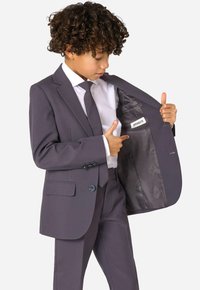 Grau Anzug mit einreihigem Sakko, mit Revers und zwei Knöpfen. Innen mit einem Etikett und glattem Futter versehen. Kombiniert mit einem weißen Hemd und einer Krawatte.