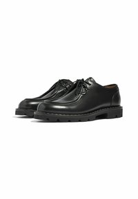 Scarpe di pelle nera con punta arrotondata, design con lacci e superficie texturizzata. Suole spesse e robuste con battistrada pronunciato.