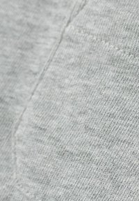 Tessuto grigio con una superficie leggermente testurizzata, caratterizzato da un delicato motivo melange. Dettagli delle cuciture visibili lungo i bordi.