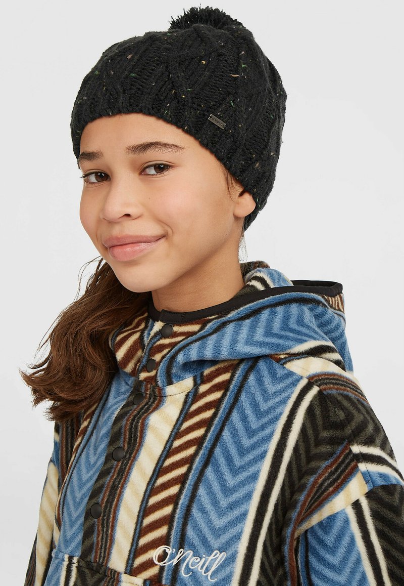 Beanie nera a maglia con un design texturizzato e un pom-pom sulla sommità. Indossato con un pullover in pile a strisce multicolori con cappuccio.