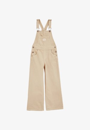 Bežinės medvilninės kombinezonas su plačiomis kojomis, kuriame yra reguliuojamos petnešos, penki kišenės ir mygtukų akcentai šonuose.