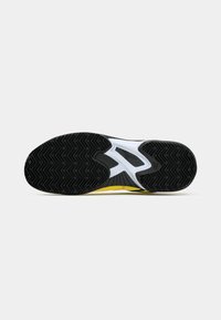Semelle en caoutchouc noir avec un motif en chevrons, semelle intermédiaire blanche avec un accent jaune, forme courbée conçue pour la performance athlétique.