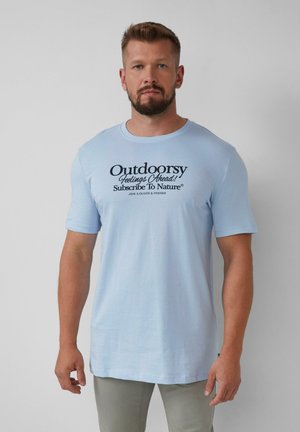Helles blaues Baumwoll-T-Shirt mit kurzen Ärmeln und rundem Ausschnitt. Der Frontdruck lautet: "Naturverbundene Gefühle voraus! Abonniere die Natur."