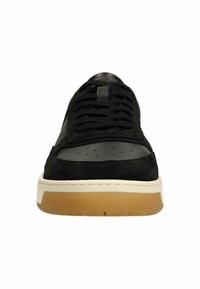 Zwarte sneaker met een bovenwerk van suede, geperforeerde neus, leren accenten, witte tussenzool en een rubberen gum outsole.