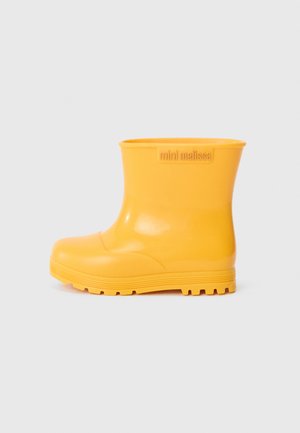 Gelbe Gummiregenstiefel mit einer glatten, glänzenden Oberfläche, Knöchelhöhe, abgerundeter Zehenpartie, horizontalen Rillen auf der Sohle und einem Logo an der Seite.