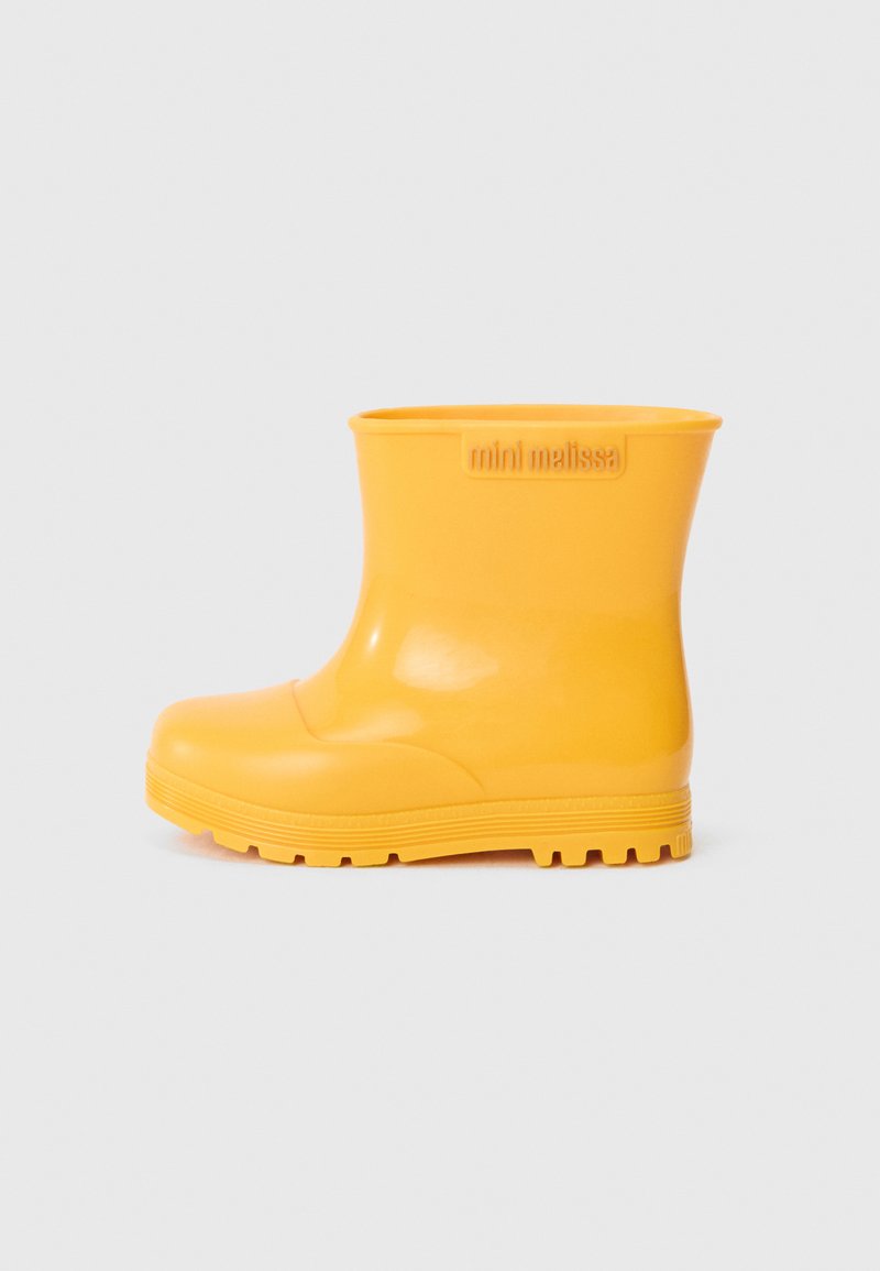 Bottes de pluie en caoutchouc jaunes avec une surface lisse et brillante, hauteur cheville, bout arrondi, rainures horizontales sur la semelle et un logo sur le côté.