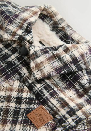Karierte Shirtjacke in Schwarz, Weiß und Braun. Verfügt über ein weiches, leichtes Futter, einen knöpfbaren Kragen und ein Lederpatch mit der Aufschrift "AUTHENTIC GOODS."
