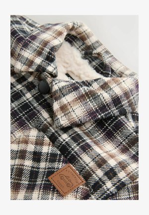 Karirana košulja jakna u crnoj, bijeloj i smeđoj boji. Ima mekan, lagan podstavu, ovratnik s dugmadima i kožni aplikator s oznakom "AUTENTIČNA ROBE."