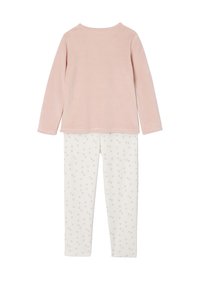 Pink long-sleeve top made of soft fabric paired with white pajama bottoms featuring grey dot patterns. Simple, functional design.