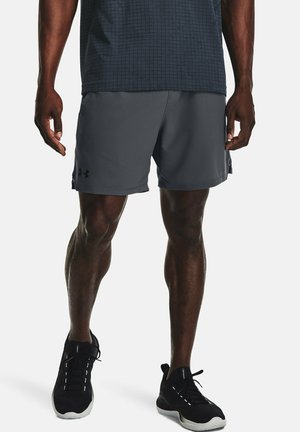 Shorts de sport gris en tissu léger, présentant une texture douce et un branding discret. Portés avec des chaussures de sport noires.