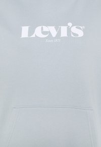 Felpa blu chiaro con tasca frontale, caratterizzata da un logo bianco "Levi's" e il testo "Dal 1873" al centro. Tessuto morbido e liscio.