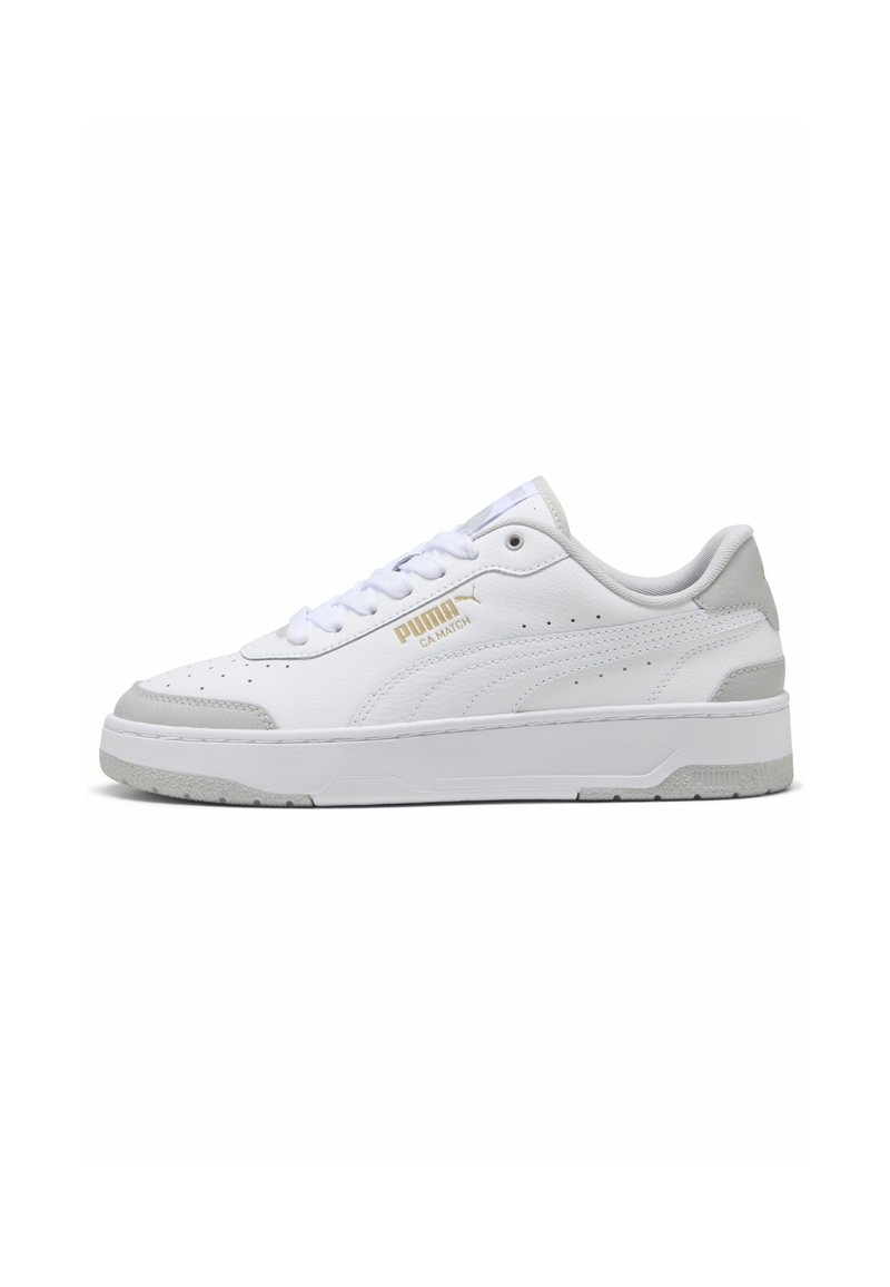 Hvide lædersneakers med lysegrå accenter, perforerede detaljer, flade snørebånd og en tekstureret gummisål. Guld branding på siden.