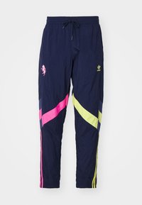 Pantaloni della tuta navy con strisce diagonali rosa, gialle e blu. Presentano un elastico in vita con cordino e dettagli con logo.