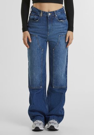 Loose-fitting blue denim jeans with patch pockets, high waist, and wide legs. Features button closure and subtle fading details.