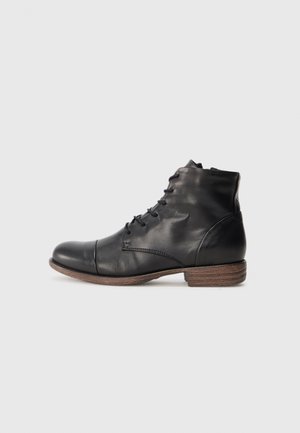 Bottine en cuir noir avec une texture lisse, bout arrondi, cinq œillets pour les lacets et un talon en bois empilé.