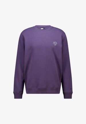 Sudadera de cuello redondo morada con mangas largas, pequeño logotipo abstracto blanco en el pecho izquierdo y pequeño emblema en el puño izquierdo.