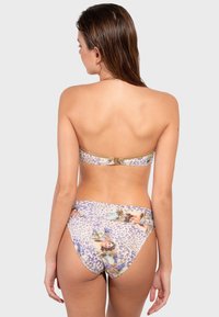 Bikini set s leopar dom a kvetinovou potlačou. Vrchná časť je bez ramienok s zlatým zapínaním. Spodná časť má vysoký strih.