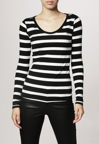 Schwarz-weiß gestreiftes Langarmoberteil mit Rundhalsauschnitt, aus einem weichen Stoff gefertigt. Mit auffälligen horizontalen Streifen und einem kleinen Logo auf der Brust.