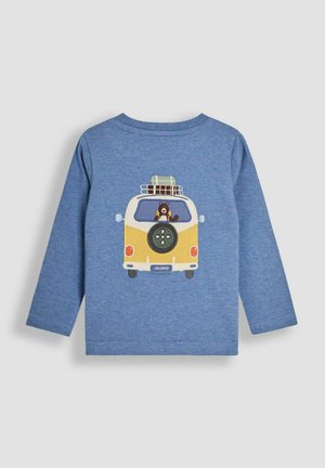 Zila krekla ar garām piedurknēm ar zīmējumu, kurā attēlots dzeltena un balta krāsa zīmēts furgons, kurā iekšā ir brūns lācis, uz kura jumta redzams bagāžas un riepas attēls.