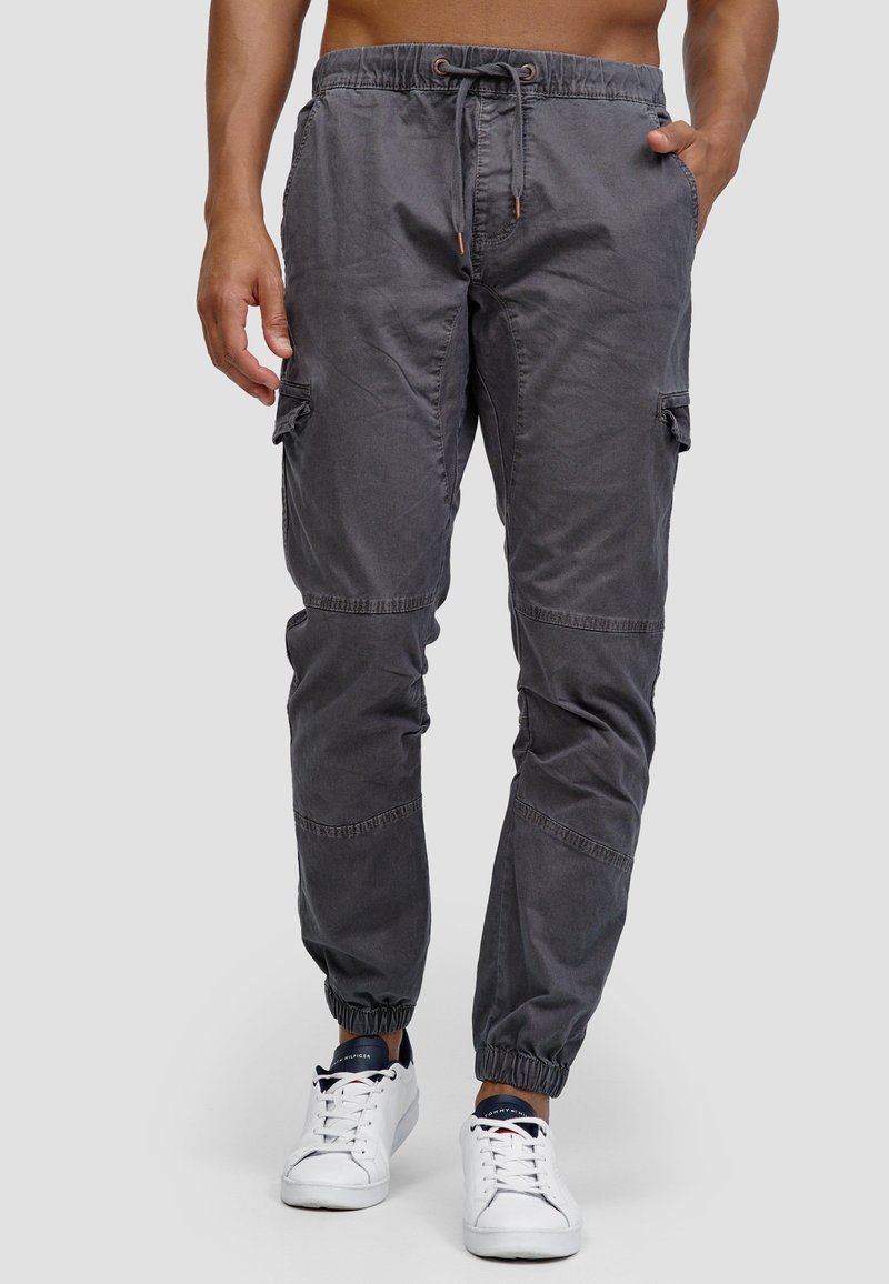 Graue Cargo-Hosen aus Baumwolle mit elastischem Bund, Kordelzug, Seitentaschen und elastischen Bündchen an den Knöcheln.