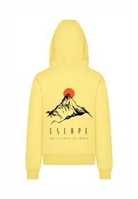 Yellow hoodie featuring a graphic of a mountain and a sun. The design includes the text "ESCAPE AND DISCOVER THE WORLD" beneath the illustration.
