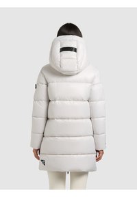 Svijetlosivi puhasti kaput s uklonjivim kapuljačom, s prošivenim dijelovima, crnom logotip oznakom i dizajnom do sredine bedara. Teksturirani završetak.