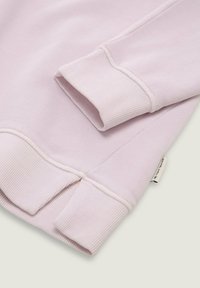 Lichtroze sweatshirt met ribgebreide boorden en onderrand. Zachte stofstructuur, met een label met branding nabij de onderrand.
