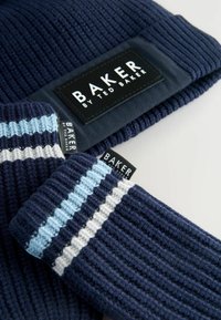 Marine gebreide beanie en vingerloze handschoenen met lichtblauwe en witte strepen, met opvallende "BAKER by Ted Baker" labels.