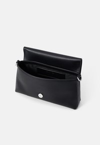 Borsa a spalla in pelle nera con chiusura a pattina magnetica, accessori cilindrici in argento e una tasca interna piatta.