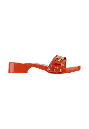 Sandalo slip-on in pelle verniciata rossa con tacco basso a blocco, cinturino largo, fibbia dorata e dettagli borchiati su sfondo bianco.