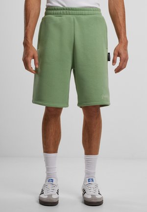 Green cotton blend shorts with an elastic waistband, side pockets, and a logo detail. Features a relaxed fit and knee-length design.
