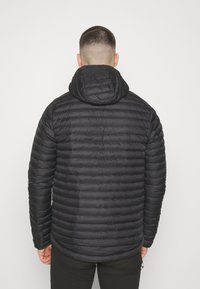 Černá péřová bunda s kapucí, s prošívaným designem a horizontálním švem. Hladká textura s mírně lesklým povrchem.