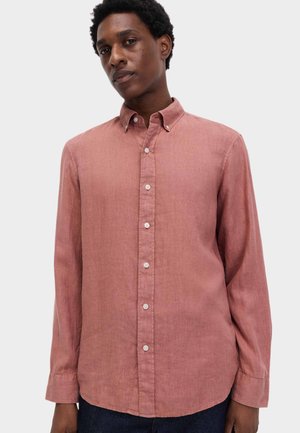 Langærmet skjorte med knapper i blødt pink stof. Har en almindelig krave og knaplukning foran. Glat tekstur med en afslappet pasform.