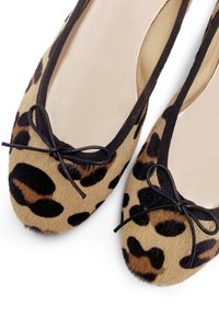 Scarpe flat con stampa leopardata, dotate di una superficie morbida e testurizzata, con rifinitura nera e dettaglio a fiocco sulla punta. Fodera interna beige.