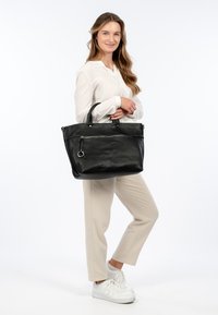Schwarze Leder-Tote mit strukturierter Form, oberen Griffen und einer Reißverschlusstasche. Verfügt über eine strukturierte Oberfläche und silberne Hardware-Akzente.
