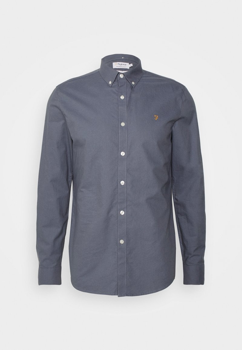 Ciemnoszara koszula na guziki z kołnierzykiem, długimi rękawami i małym złotym logo na piersi. Posiada białe guziki i gładką teksturę tkaniny.