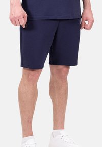 Shorts de sport bleu marine en tissu doux, avec une coupe droite, une taille élastique et des poches latérales pour plus de commodité.
