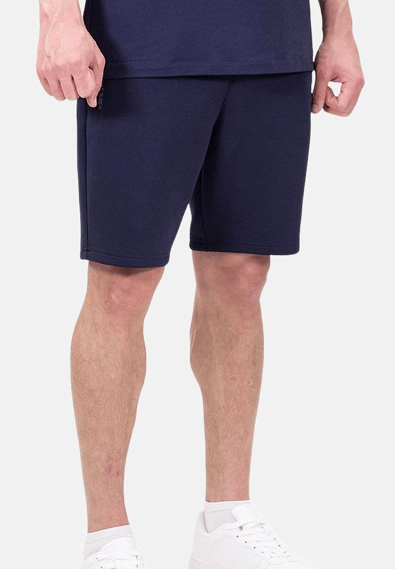Shorts de sport bleu marine en tissu doux, avec une coupe droite, une taille élastique et des poches latérales pour plus de commodité.