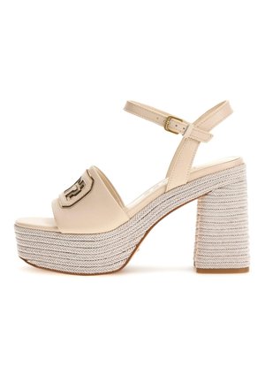 Sandali platform beige con una larga fascia curva e una fibbia ampia. Il tacco intrecciato e testurizzato presenta un spesso motivo a spina di pesce e una suola piatta.