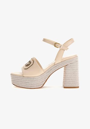 Sandali platform beige con una larga fascia curva e una fibbia ampia. Il tacco intrecciato e testurizzato presenta un spesso motivo a spina di pesce e una suola piatta.