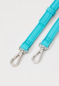 Cintura in tessuto turchese con clip metalliche in argento, caratterizzata da una superficie liscia e un design piatto. Due clip attaccate per una maggiore versatilità.