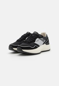 Zapatillas negras con una mezcla de materiales textiles y de ante, con una entresuela blanca, acentos texturizados y detalles de logotipo en el costado.