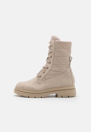 Botte d'hiver beige à lacets avec tige rembourrée, semelle robuste et languette d'extraction, conçue pour le temps froid et les activités en plein air.