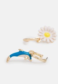 Brincos em tom de ouro com um golfinho em esmalte azul e uma margarida branca com um centro amarelo, apresentando formas distintas e cores vibrantes.
