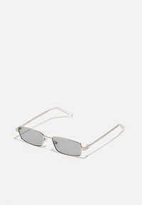 Lunettes de soleil avec des verres rectangulaires teintés gris ; monture en métal argenté fine ; branches transparentes ; design minimaliste sans motifs ni accents visibles.