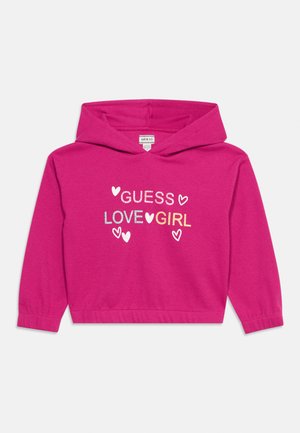 Lyserød hættetrøje til børn med teksten "GUESS LOVE GIRL" og hjerte-designs på forsiden, ribkant ved ærmeafslutning og kant.