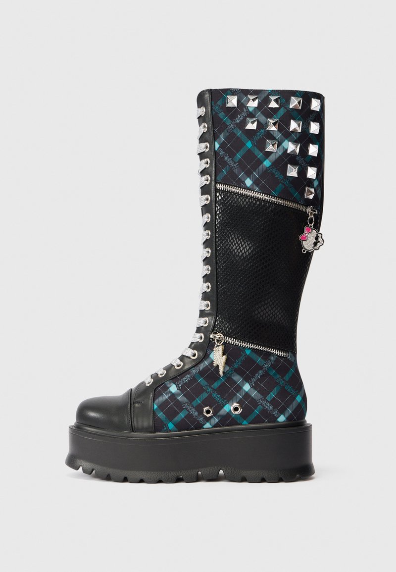 Knee-high čierne a teal kárované čižmy s kovovými cvočkami, zipsami a platformovou podrážkou. Obsahujú strieborné šnúrky a dekoratívne prívesky.