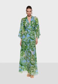 Long, flowing dress in blue and green floral pattern, featuring kimono sleeves, a wrap design, and a tied waist. Fabric appears lightweight.