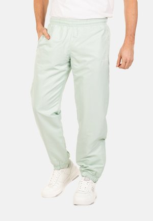 Lichtgroene, lichte sportieve broek met een elastische tailleband en boorden; heeft zijzakken en een subtiele merklogo op de dij.